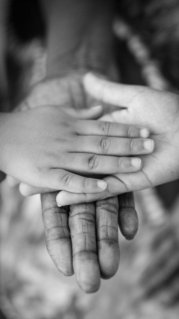 Child's hand on woman's hand on man's hand